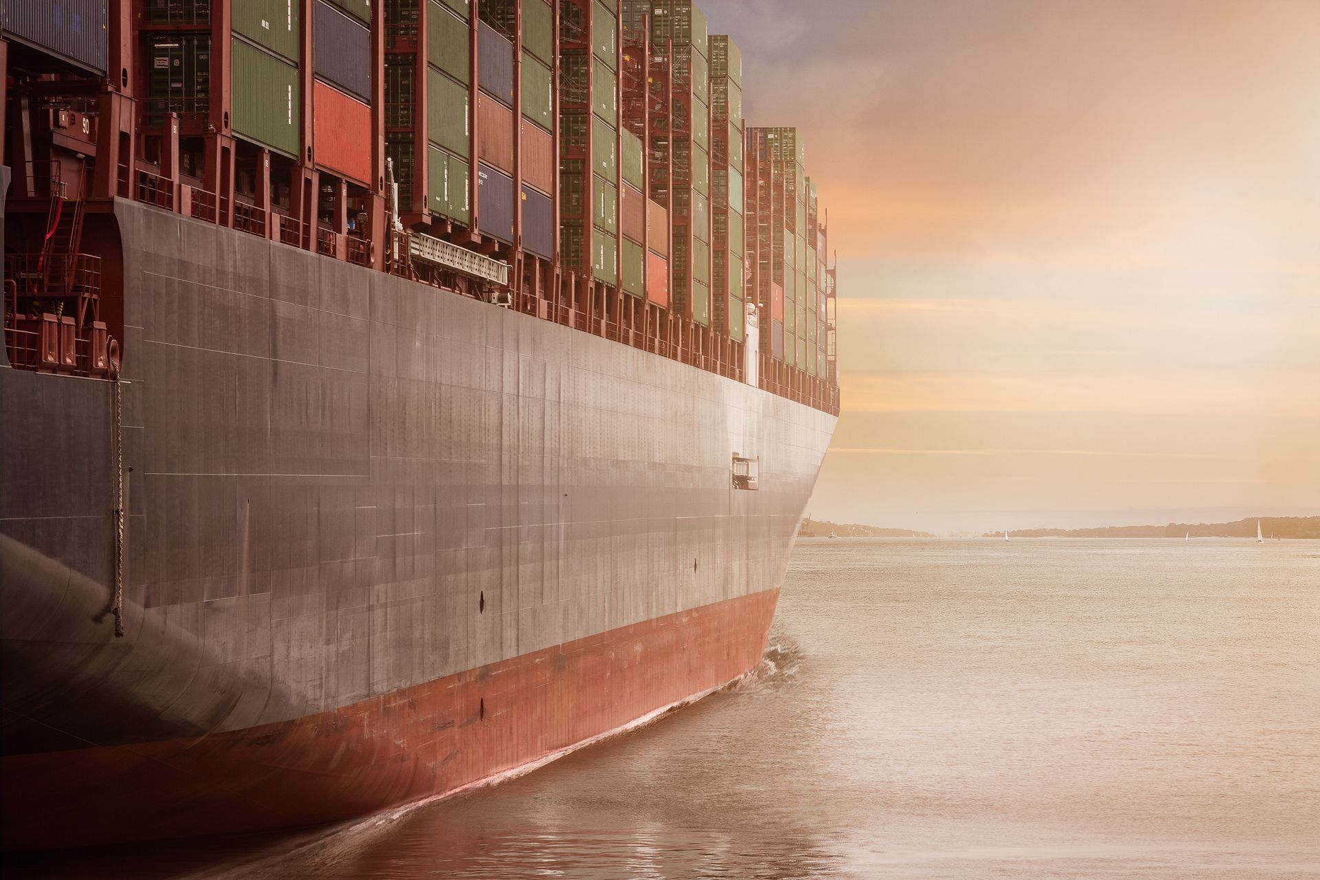 Laden container vessel under way at sunset